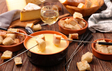 traditional cheese fondue with bread and glass of wine
