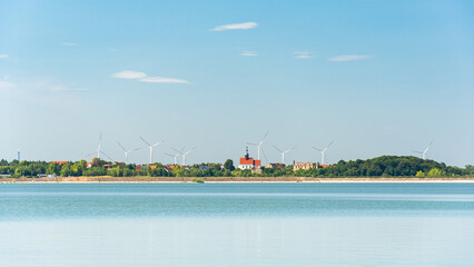 Mietkowski Reservoir, view of the town of Mietkow and the nearby wind farm. A popular place for summer recreation and water sports, view from the water on a summer day.
