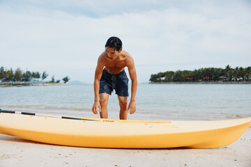 Happy Asian Man Kayaking in Tropical Paradise: Adventure and Leisure on a Beach