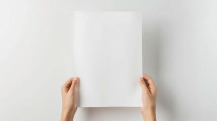 Hands hold up a blank sheet of paper against a white background, ready for creativity and ideas.