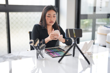 Asian girl makeup artist Professional Woman blogger vlogger is showing cosmetics products with...
