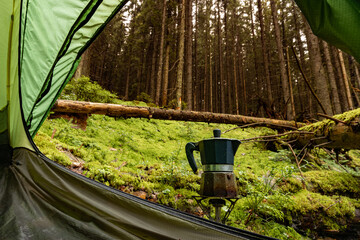 Morning on a hike in the mountains, making coffee on a gas burner.