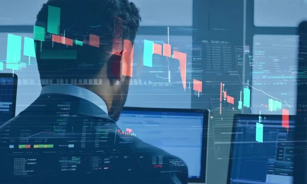 Portrait of Financial Analyst Working at Multi-Monitor Workstation with Real-Time Market Charts