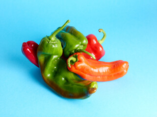 Assortment of long sweet peppers over blue background