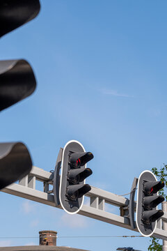 A close-up view of traffic lights, starkly standing out against a clear blue sky, symbolizing traffic control, urban infrastructure, and everyday life intersections.