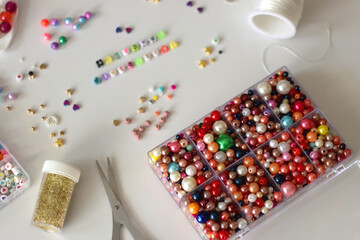 Making friendship bracelets with letter beads. Jewelry making supplies on the table. Selective focus.