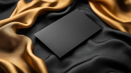 Black Invitation Card,  An elegant black card resting on luxurious fabric with gold and black silks, ideal for branding or sophisticated invitations