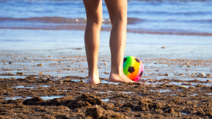 People playing soccer on the beach, just feet and a ball.