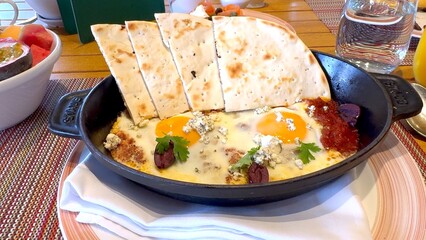 Poached eggs in vibrant tomato sauce flavored with olive oil and pita bread offer luxurious start to your day Dish combines simplicity of natural ingredients with sophistication of clean eating