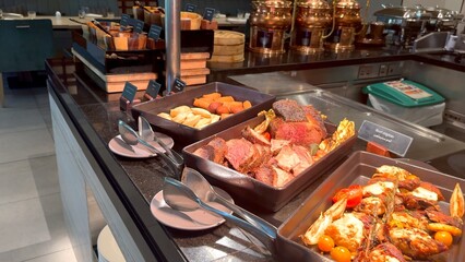 Roast beef and perfectly cooked potatoes take center stage at lavish lunch buffet in 5-star hotel Gourmet presentation is matched by luxurious setting offering refined flavorful dining experience.