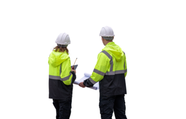 Engineers wearing safety gear, including hard hats examining survey a tablet standing industrial facility gas task or oil refinery engaged in a job requires high safety standards concept