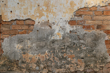 Old brick wall with crumbling cement revealing the Antique brickwork.