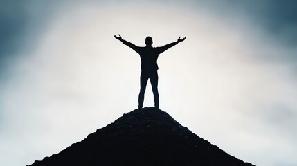 Silhouette of a person standing on top of a hill with open arms symbolizing achievement and growth
