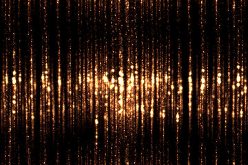 Naklejka premium christmas, new year golden warm vertical particles and sparkles with fluid movement on black background, christmas holiday and event