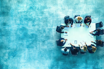 Diverse business team brainstorming and collaborating in a modern office setting, focusing on laptops and documents. Blue background adds professionalism