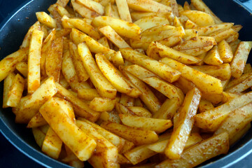 Close-Up of Seasoned French Fries in a Pan - Perfect for Food Blogs, Menus, or Recipe Books