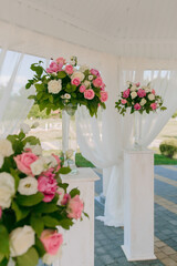 A white tent with pink flowers and white curtains