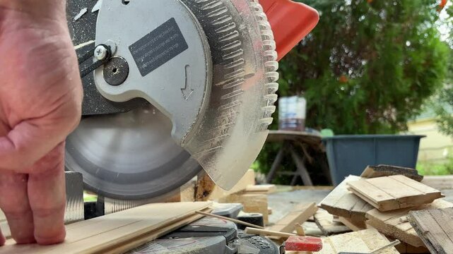 Circular saw for cutting wooden panel made of fiberboard in workshop. Carpenter equipment for Medium Density Fiberboard MDF processing. Woodworking machine with an electric circular saw. Woodworking