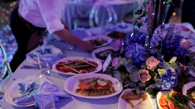 The waiter sets the dishes on the table