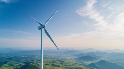 Aerial view of a wind turbine standing tall in a vibrant landscape, showcasing clean energy amid lush greenery and blue skies.
