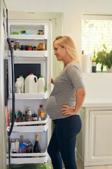 Fridge, pregnant and smile with woman in kitchen of home to search for food, meal or snack. Maternity, pregnancy and thinking with person opening refrigerator in apartment for diet or nutrition