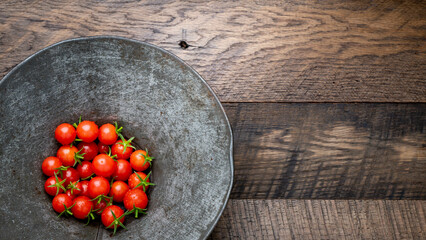 Freshly picked, ripe, red, cherry tomatoes in a vintage metal colander.