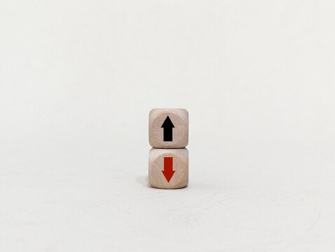 down and up arrow symbols on wooden cube. the concept of economic growth, profit in business