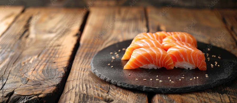 Sticker a display of fresh salmon sashimi on a black stone plate atop a wooden table featuring a background 