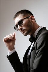 Handsome Man, Fashion model in black costume, tuxedo, bow tie and sunglasses