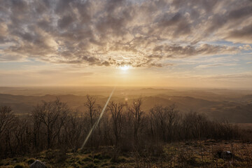 ampia vista panoramica dall'alto sul bellissimo territorio naturale tra pianura e collina, coperto da un leggero velo di nebbia, nell'Italia nord orientale, in Friuli Venezia Giulia, al tramonto
