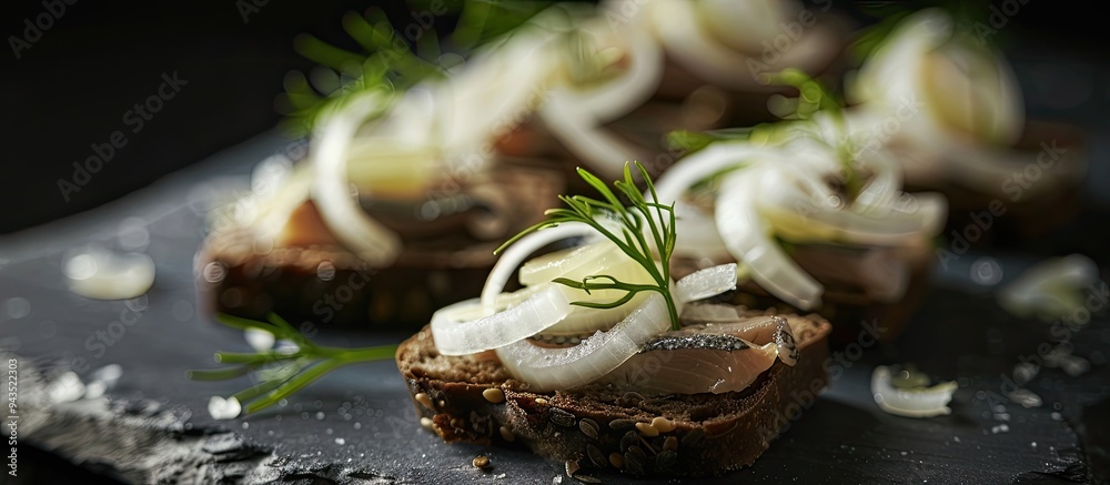 Poster a canape with salted herring onions on dark bread displayed with copy space image on a black backgro