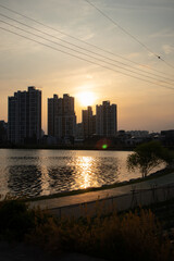 A photo of Korean buildings and lakes harmonizing with the sunset as a background
