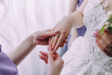 A woman is getting her hand ringed by another woman