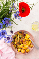 Stewed potatoes with stewed vegetables, broccoli and beans with carrots and herbs, a served table with food and a vase of flowers, a delicious hearty lunch or dinner