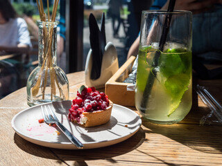 uneaten tartlet with berries on plate lit by sun