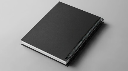 Black Spiral Notebook on Grey Background