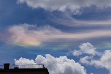 vista dettagliata di alcune nuvole iridescenti nel cielo, dai vari colori accesi, di giorno