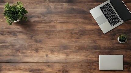 A stylish workspace featuring a laptop, notebook, and greenery on a rustic wooden desk.