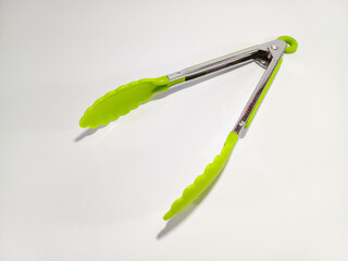 Green Kitchen Tongs in Open Condition Against a White Background: A Simple Yet Striking Presentation Highlighting the Practicality and Vibrant Color of the Tongs, Set Against a Clean, White Backdrop
