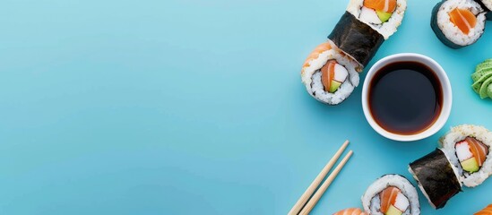 Take out sushi and maki with soy sauce on a blue background showcasing a concept of grab and go meals with copy space image