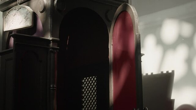 Tilt up no people shot of confession booth with open door in corner of lutheran church