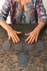 Insightful tarot reader shuffling the cards, creating a moment of suspense before revealing their...