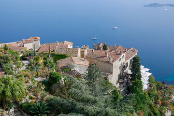 Landscape view of Eze, seen from above with gardens, roof tops on the foreground and the the mediterranean as background