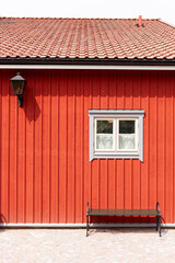 Skandinavische Architektur. Rote Hausfassade mit kleinem weißem Fenster. 
Scandinavian architecture. Red house facade with small white window. 