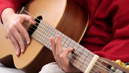 boy plays guitar. Guitar lessons online or at home for children. E-learning music lessons for acoustic guitar