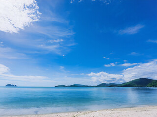 A sunlit cloudscape over sea and mountain