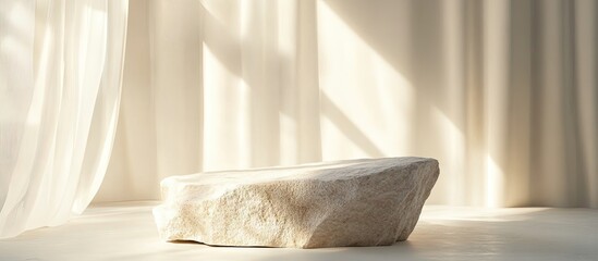 Minimal stone stage product display with sunlight streaming through a window on a cream colored background. with copy space image. Place for adding text or design