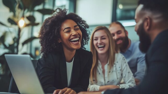 Group of colleagues enjoying a lighthearted moment during a team meeting in a modern office setting in the afternoon