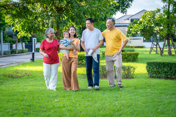 Fototapeta premium Asian family and baby are in the grass. Everyone looks happy.
