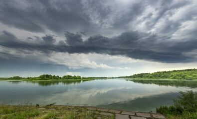 A cloudy sky over a lake with a reflection of the sky in the water